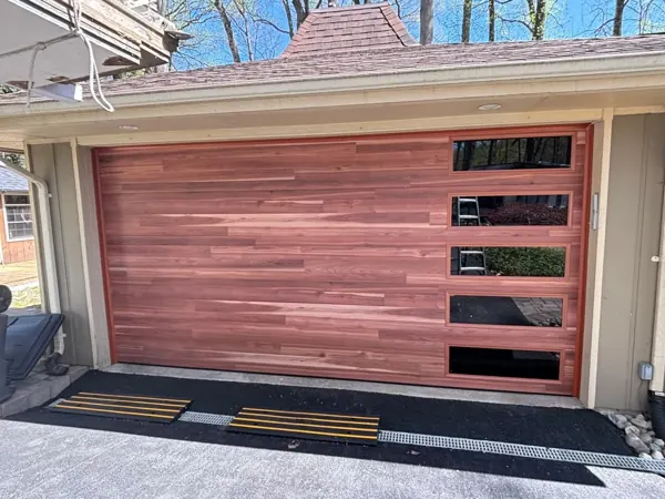 Modern wood-look garage door with a column of glass windows